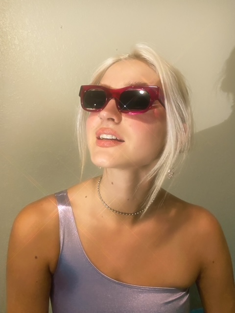 A woman with white hair wearing sunglasses